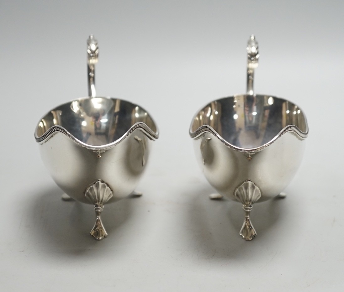 A pair of Elizabeth II silver sauce boats, with flying scroll handles, Poston Products Ltd, Birmingham, 1961, length 18cm, 11.3oz.